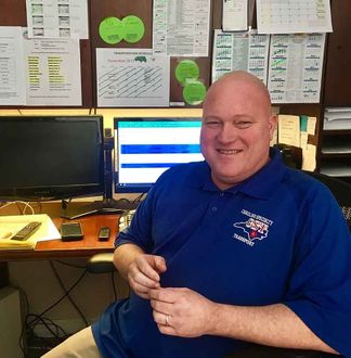 CST member smiling at desk